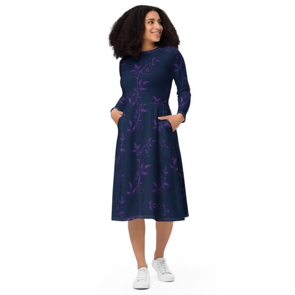 A person wearing a colorful all-over print midi dress with long sleeves and pockets. front
